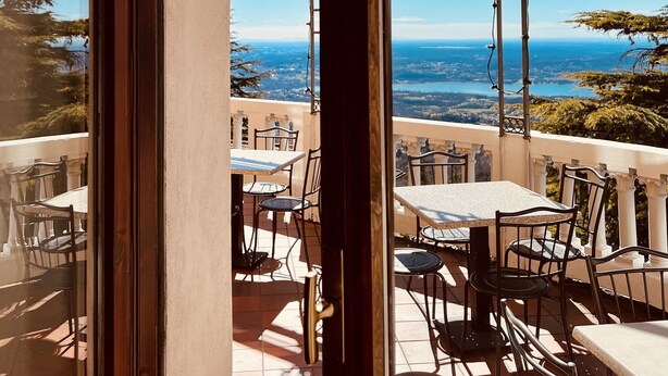 An outdoor terrace with tables and chairs, overlooking a scenic landscape. - Albergo Sacro Monte Varese (Varese)