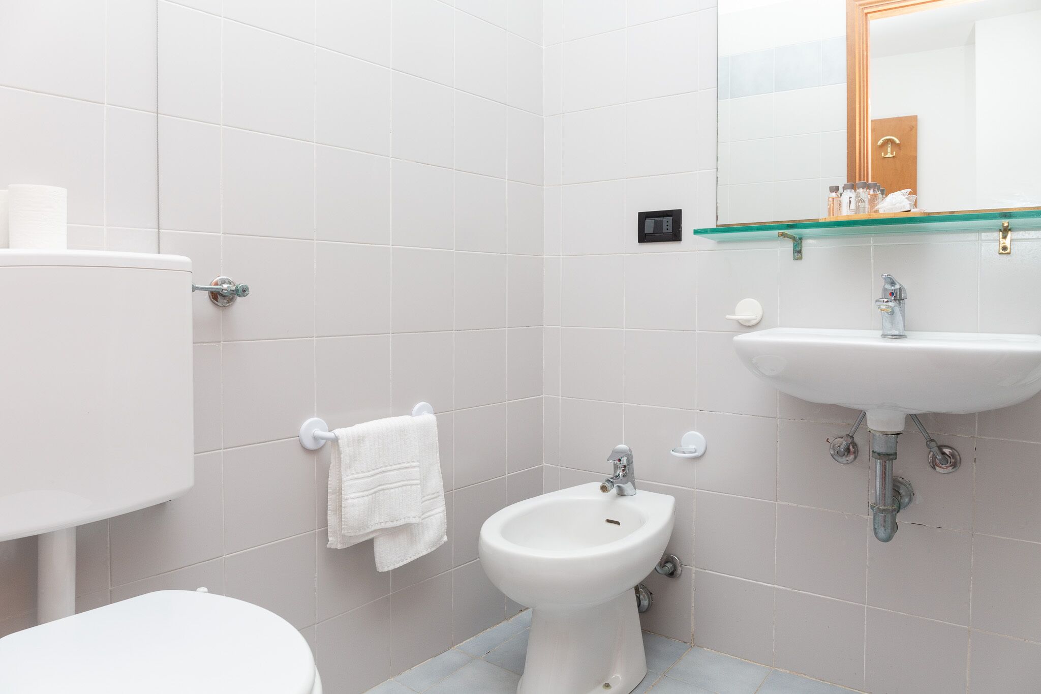 Een moderne badkamer met toilet, hygiëneschuimer en wastafel.