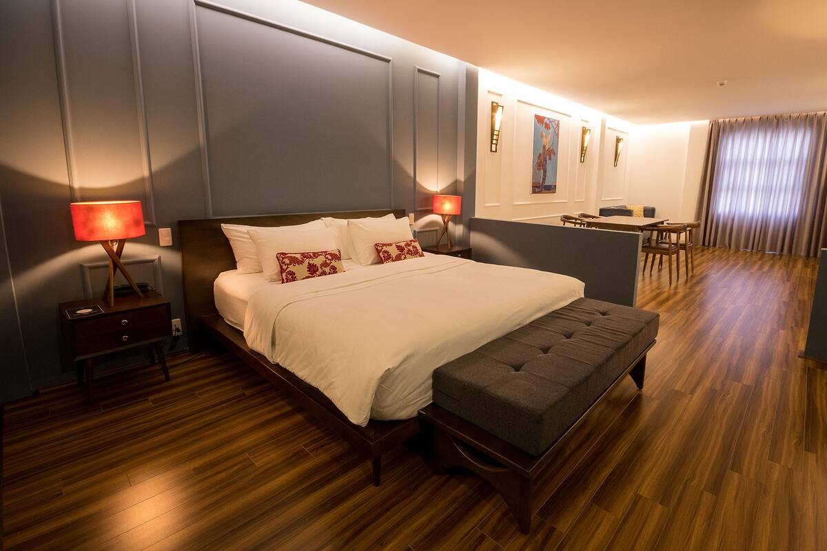 Una habitación de hotel con una cama grande, un escritorio y una zona de estar.