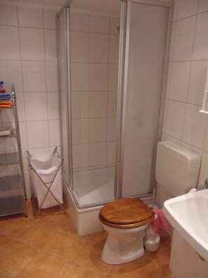 A bathroom with a shower, toilet, and sink. - Strandleben 1 (Groemitz)