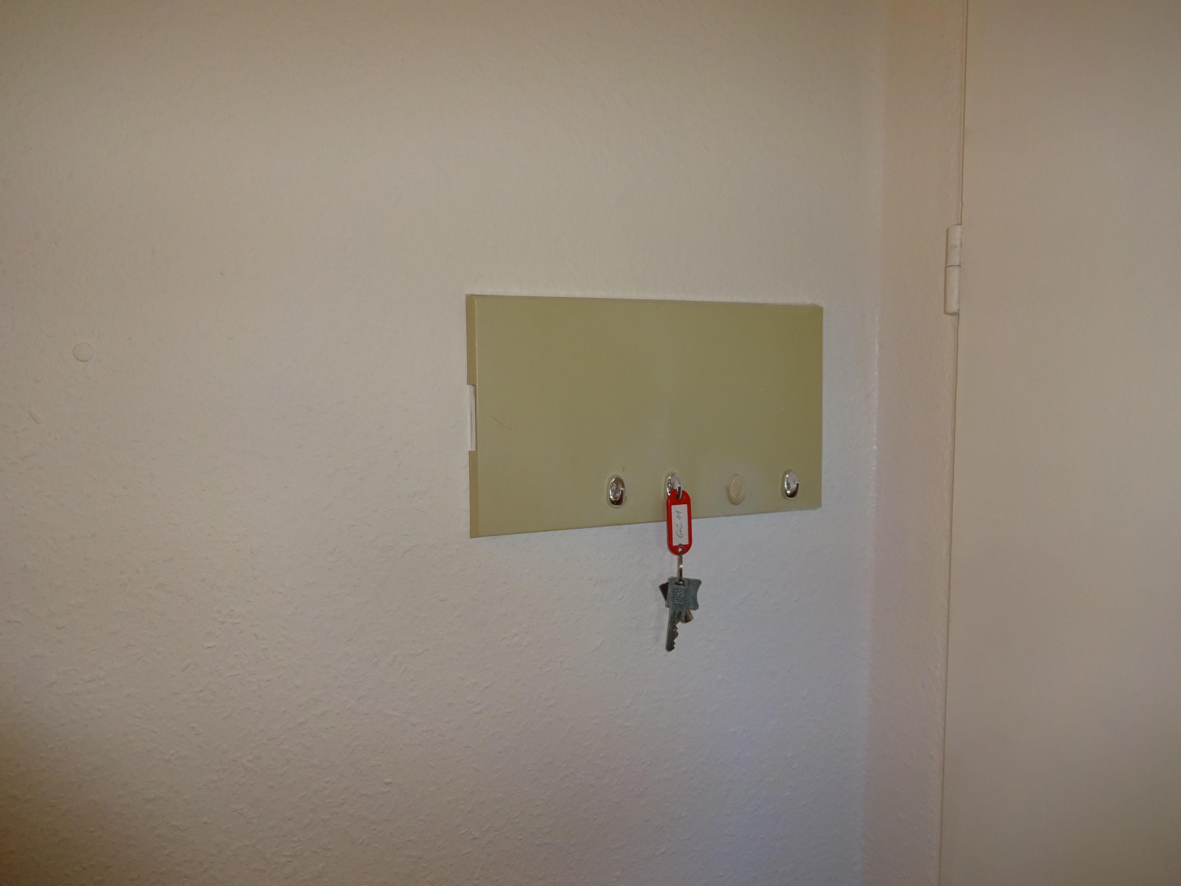 A wall-mounted control panel with a key and a red tag.