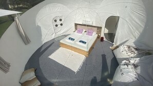 Una tenda con un letto, un tavolino e una finestra.