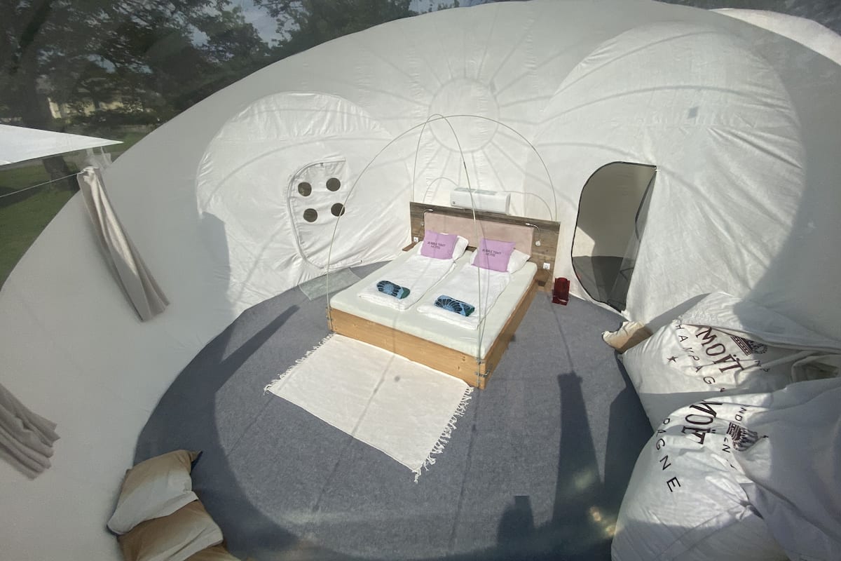 Una carpa con una cama, una mesita y una ventana.