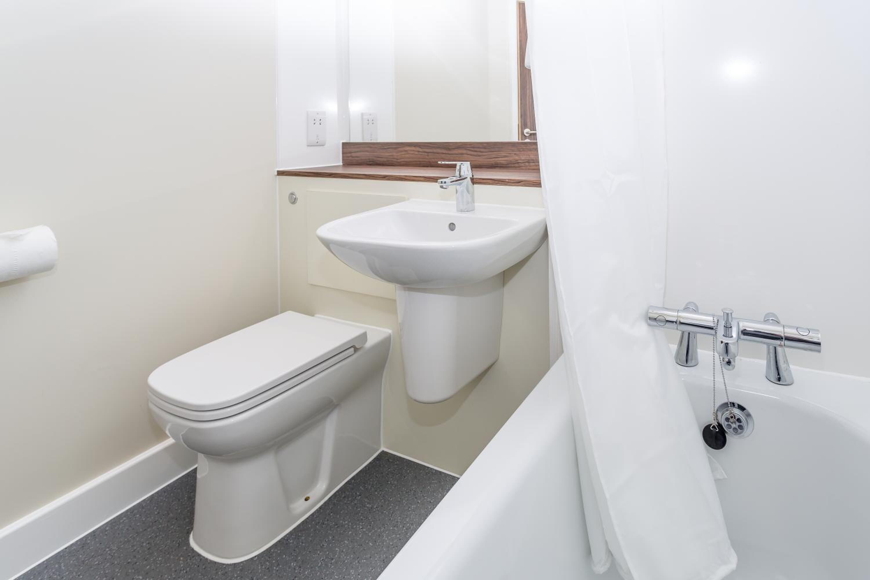 A bathroom with a toilet, sink, and bathtub.