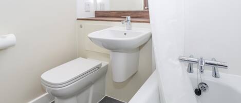 A bathroom with a toilet, sink, and bathtub.