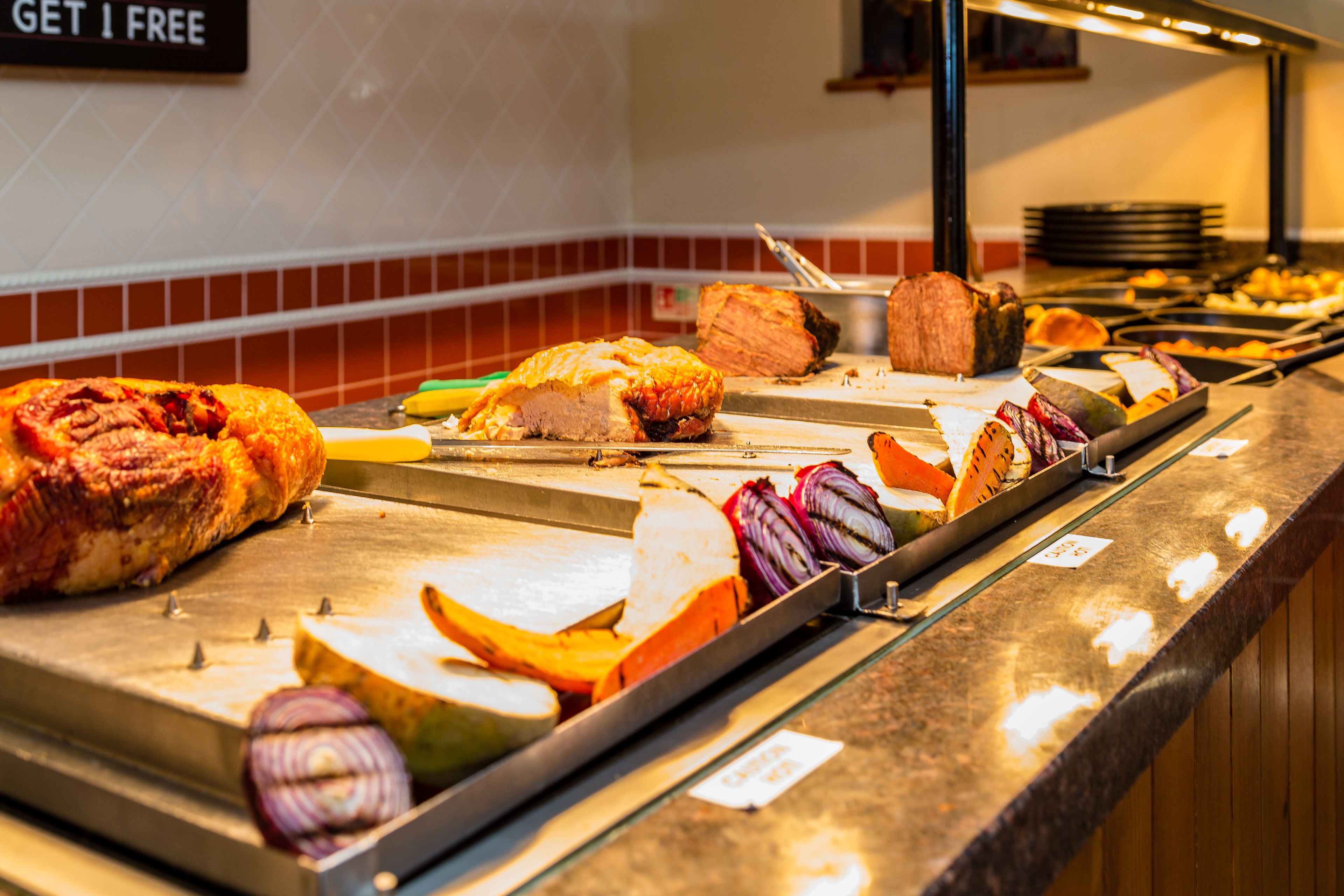A buffet with various meats and vegetables.