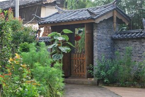 A traditional Chinese-style building with a tiled roof and a wooden gate. - Pure Yard (Lijiang)