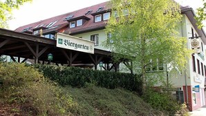 Un bâtiment sur lequel on peut lire l’inscription « Biergarten » et qui possède une allée couverte.