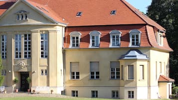 Ein großes, zweistöckiges Gebäude mit rotem Ziegeldach und einer symmetrischen Fassade.