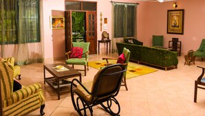 A cozy living room with a sofa, chairs, a coffee table, and a dining table. - Ocean Dream Beach Villa (Dar es Salaam)