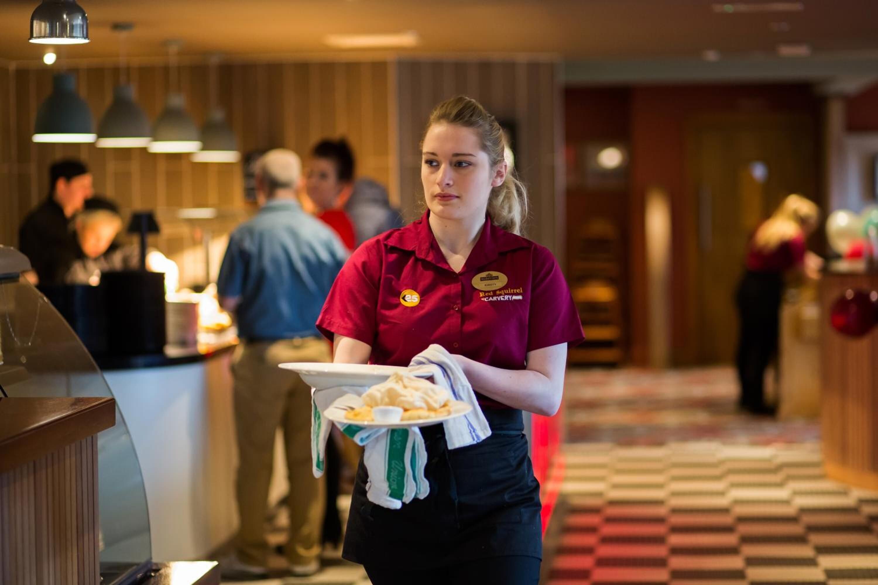 Un empleado de hotel transporta una bandeja con comida.