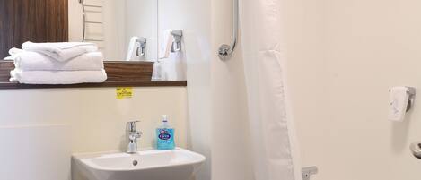 Un baño con inodoro, lavamanos, ducha y bañera.