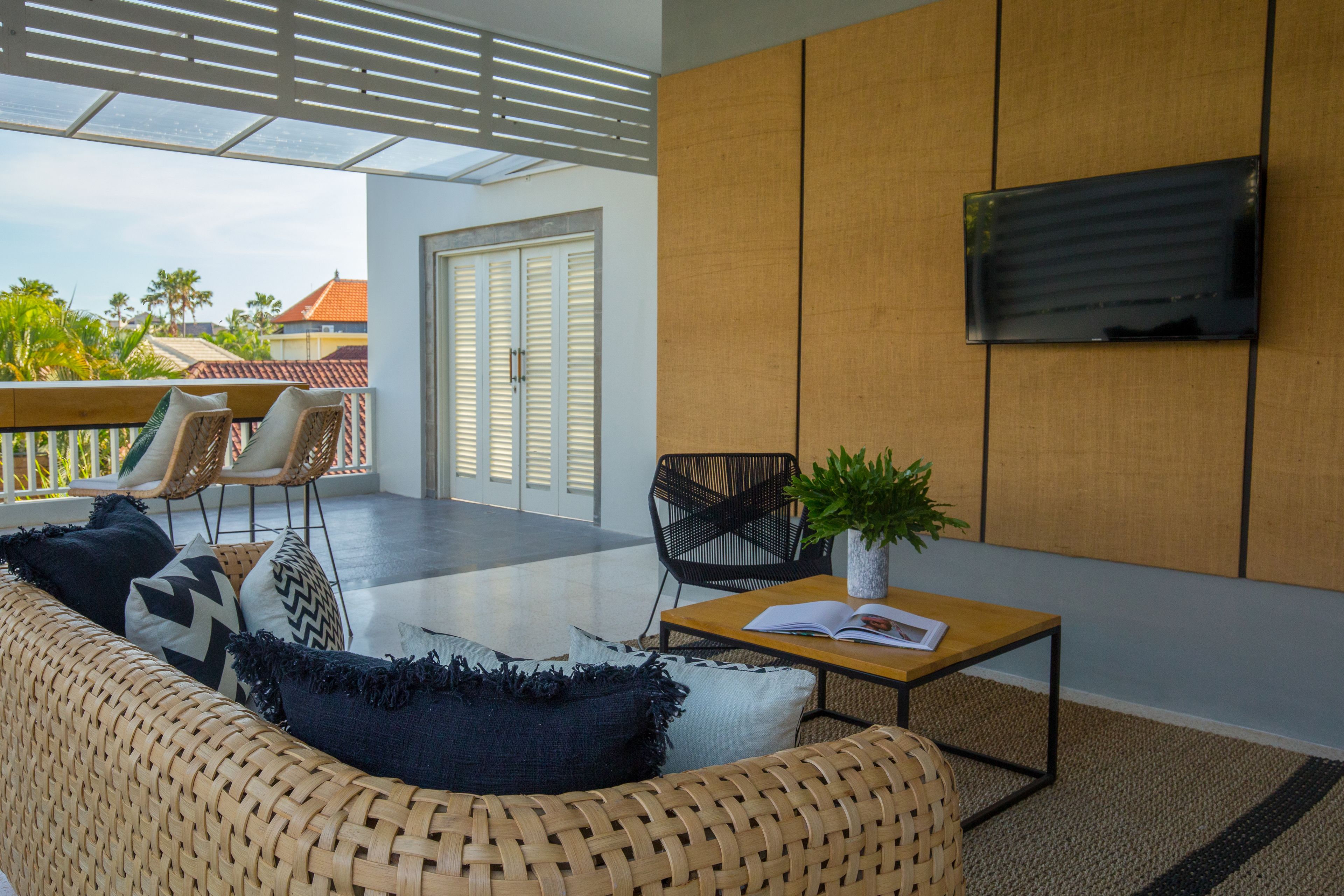 A modern living room with a sofa, chairs, a table, and a TV.