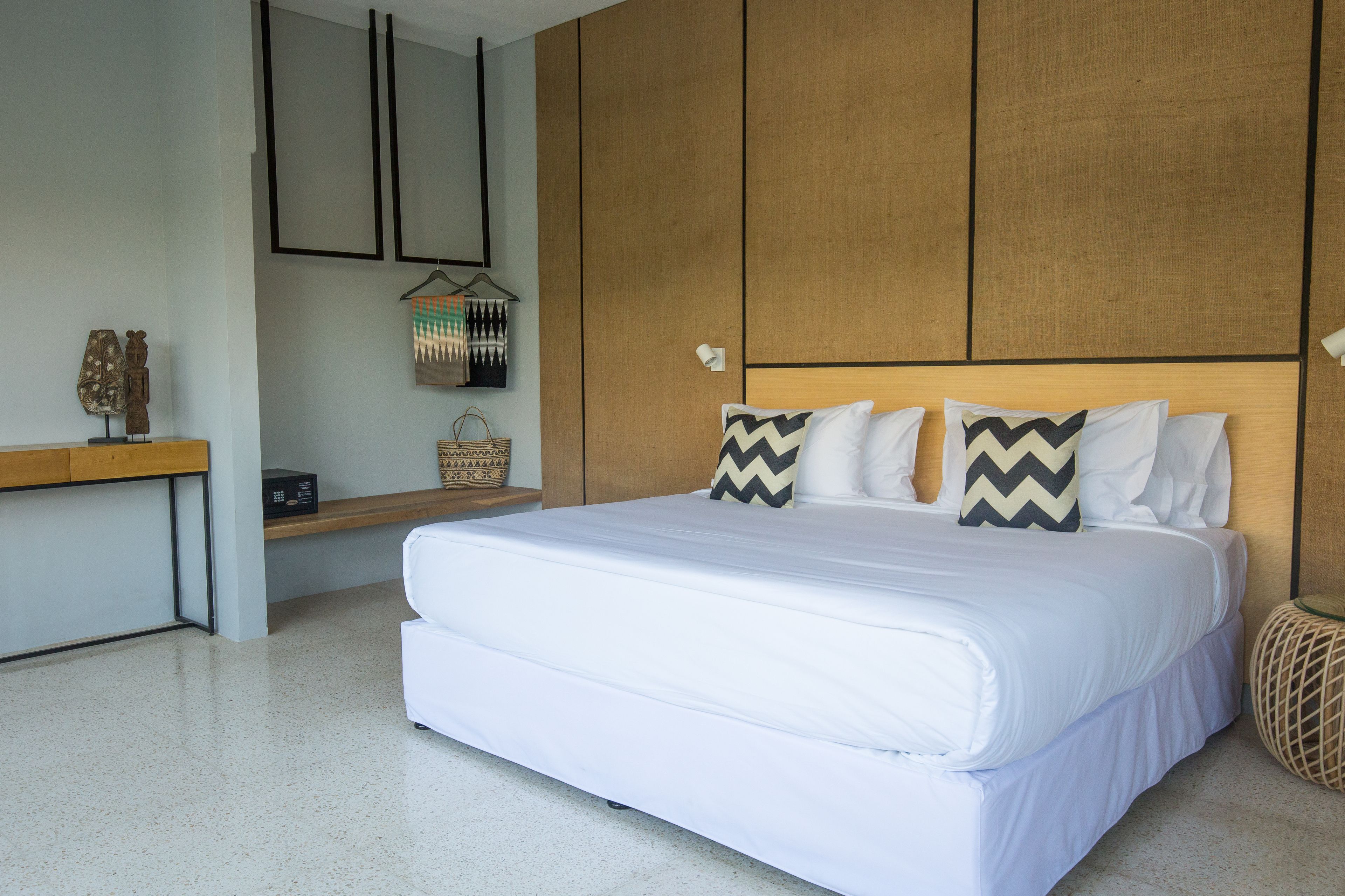 Una camera da letto moderna con un letto grande, una testiera in legno e un comodino con una lampada.