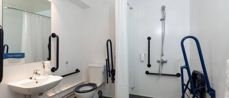 A modern bathroom with a white sink, toilet, and shower area.