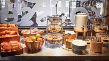 A buffet setup with various food items and serving utensils.