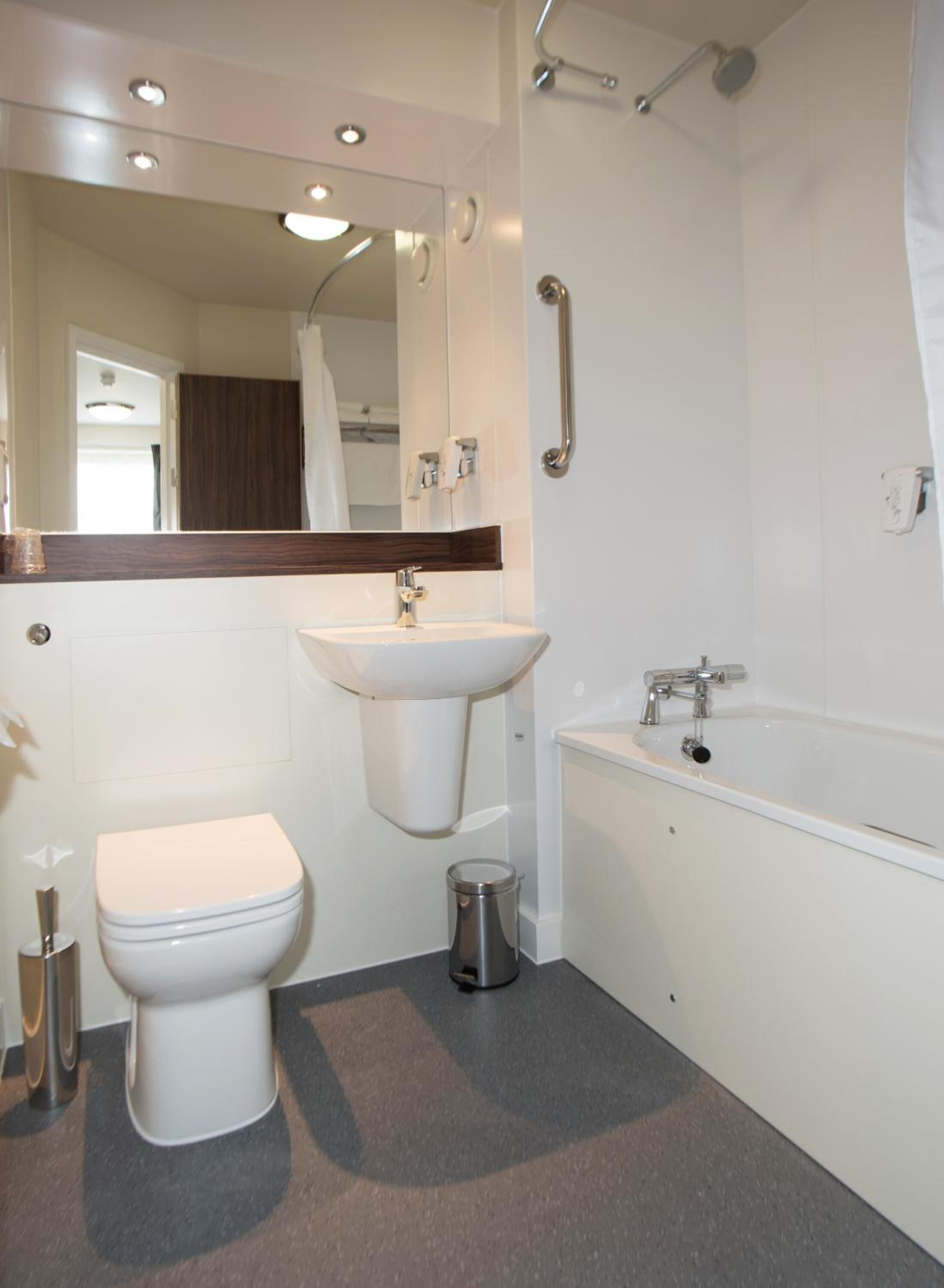 A modern bathroom with a toilet, sink, and bathtub.