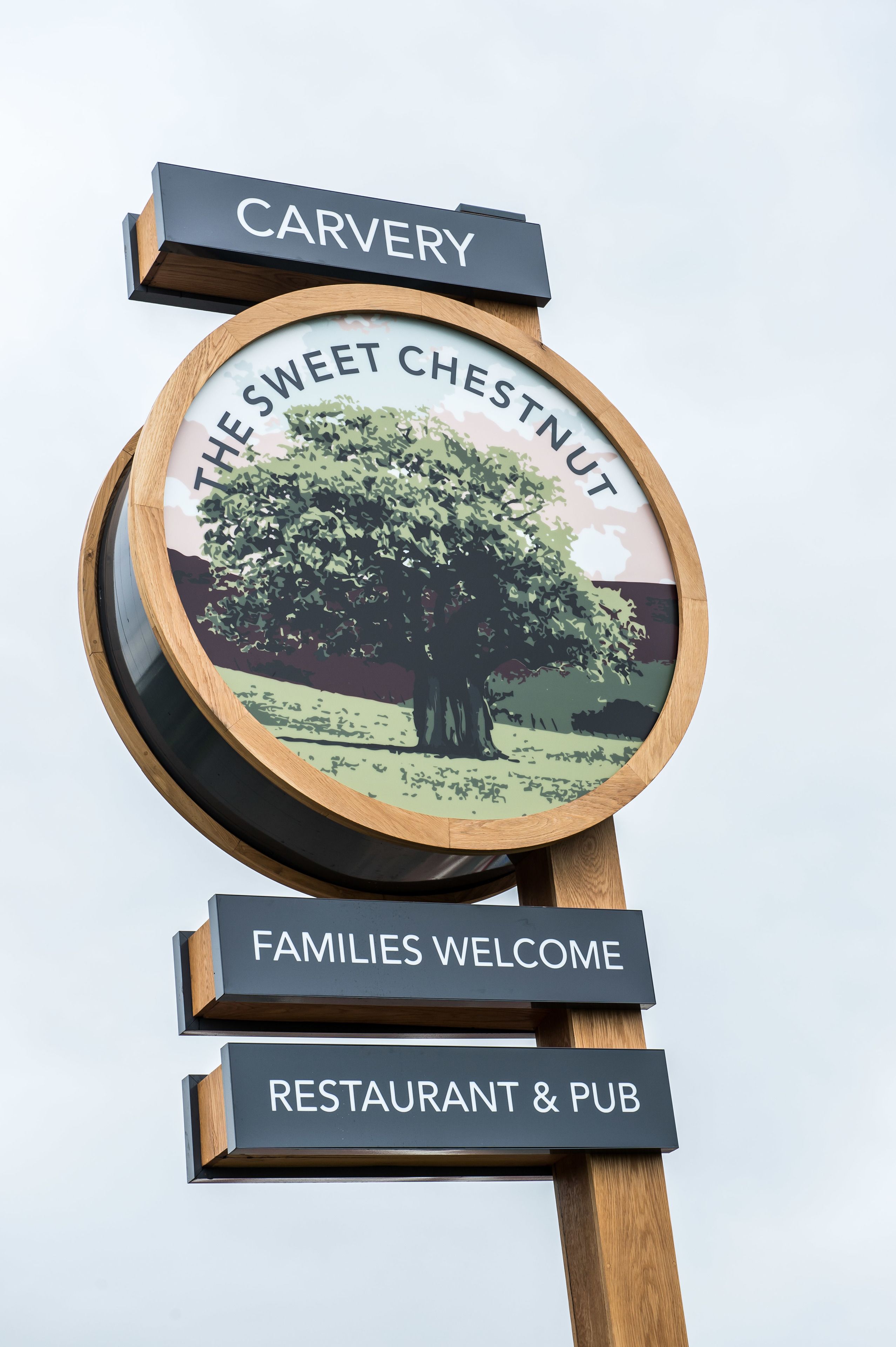 A sign with 'CARVERY' at the top, 'THE SWEET CHESTNUT' in the center, and 'FAMILIES WELCOME' and 'RESTAURANT & PUB' at the bottom.