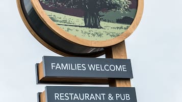 Un letrero con 'CARVERY' en la parte superior, 'THE SWEET CHESTNUT' en el centro y 'FAMILIES WELCOME' y 'RESTAURANT & PUB' en la parte inferior.