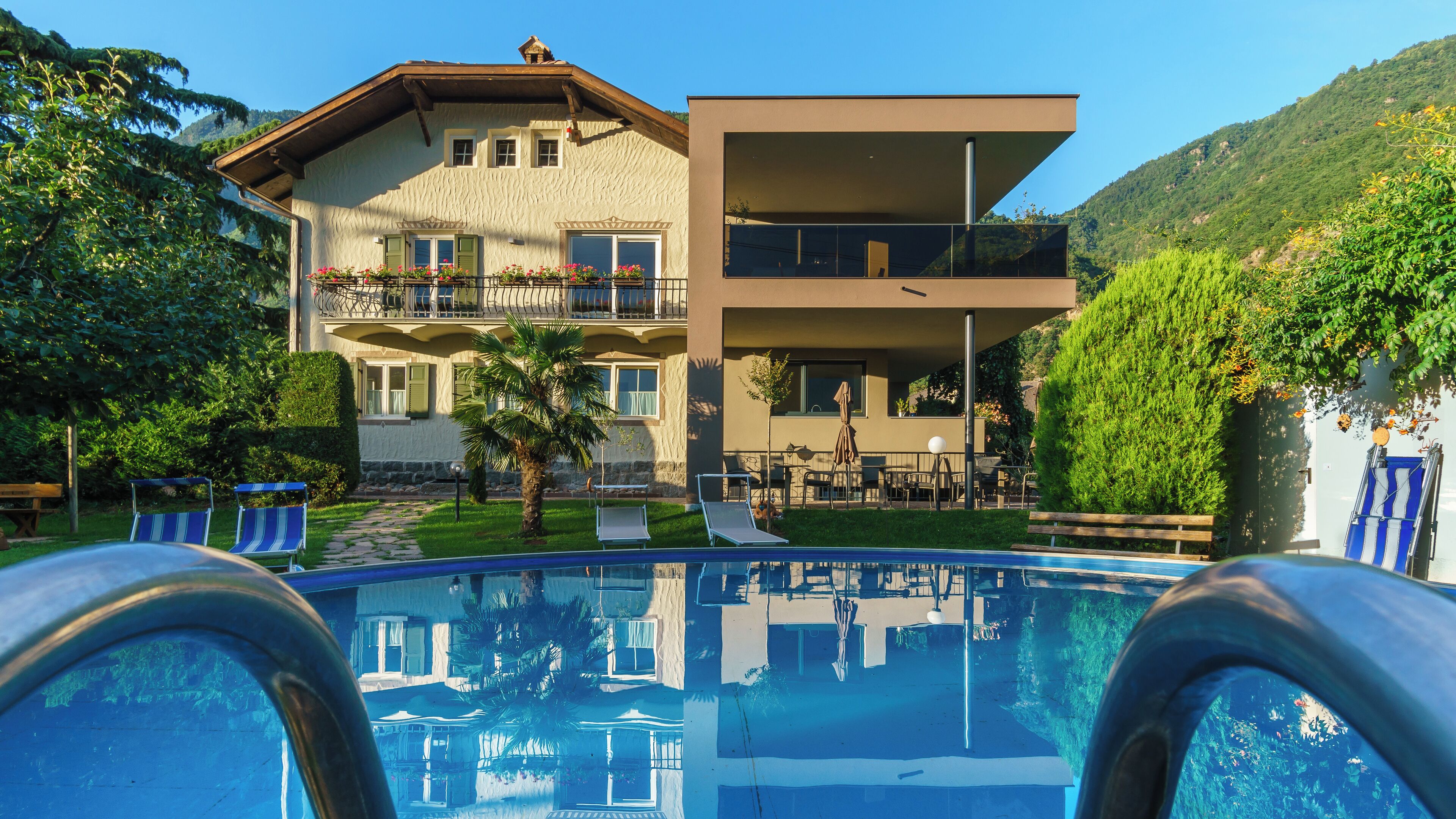 A modern two-story building with a pool in the foreground.