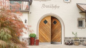 A building with a large wooden door and the name "Sunnhofer" above it. - Pension Sunnhofer (Terlano)