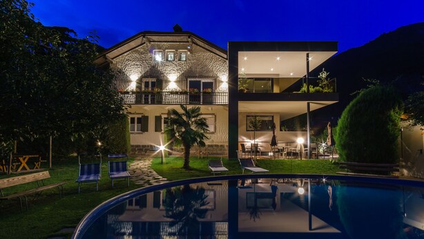 A two-story house with a swimming pool in the foreground. - Pension Sunnhofer (Terlano)