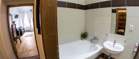 Un baño moderno con bañera, lavamanos y espejo.