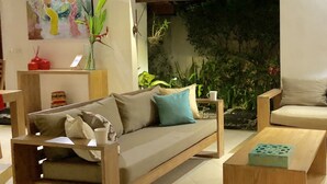 Uma sala de estar aconchegante com sofá, mesa de centro e detalhe decorativo na parede.
