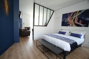 Quarto com cama, banco e pintura na parede.
