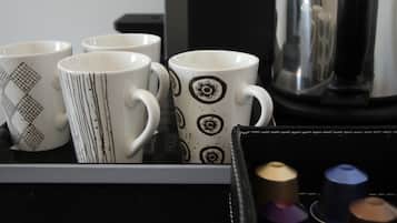 A coffee machine and a tray with mugs and coffee capsules.