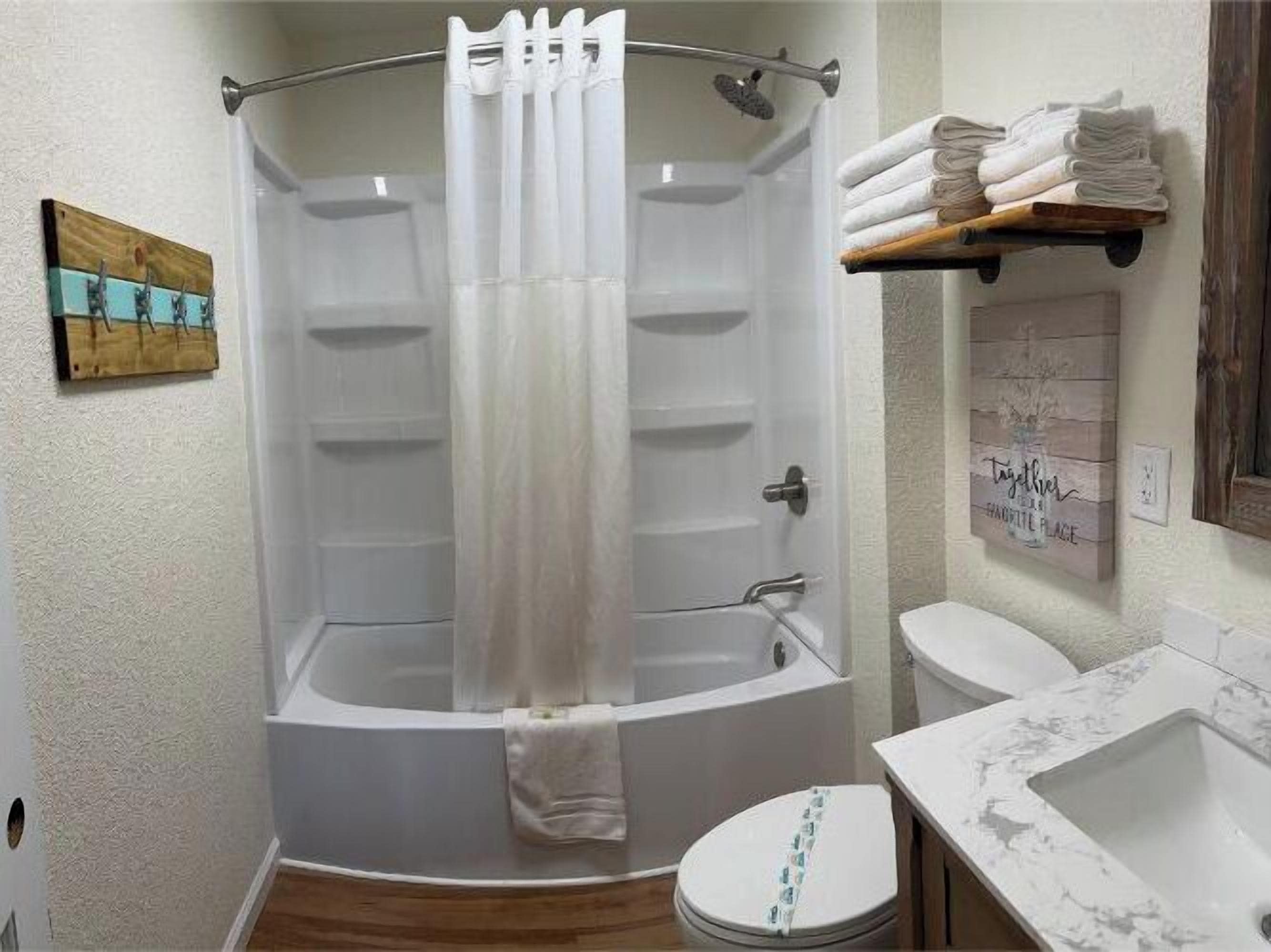 A bathroom with a bathtub, toilet, and sink.