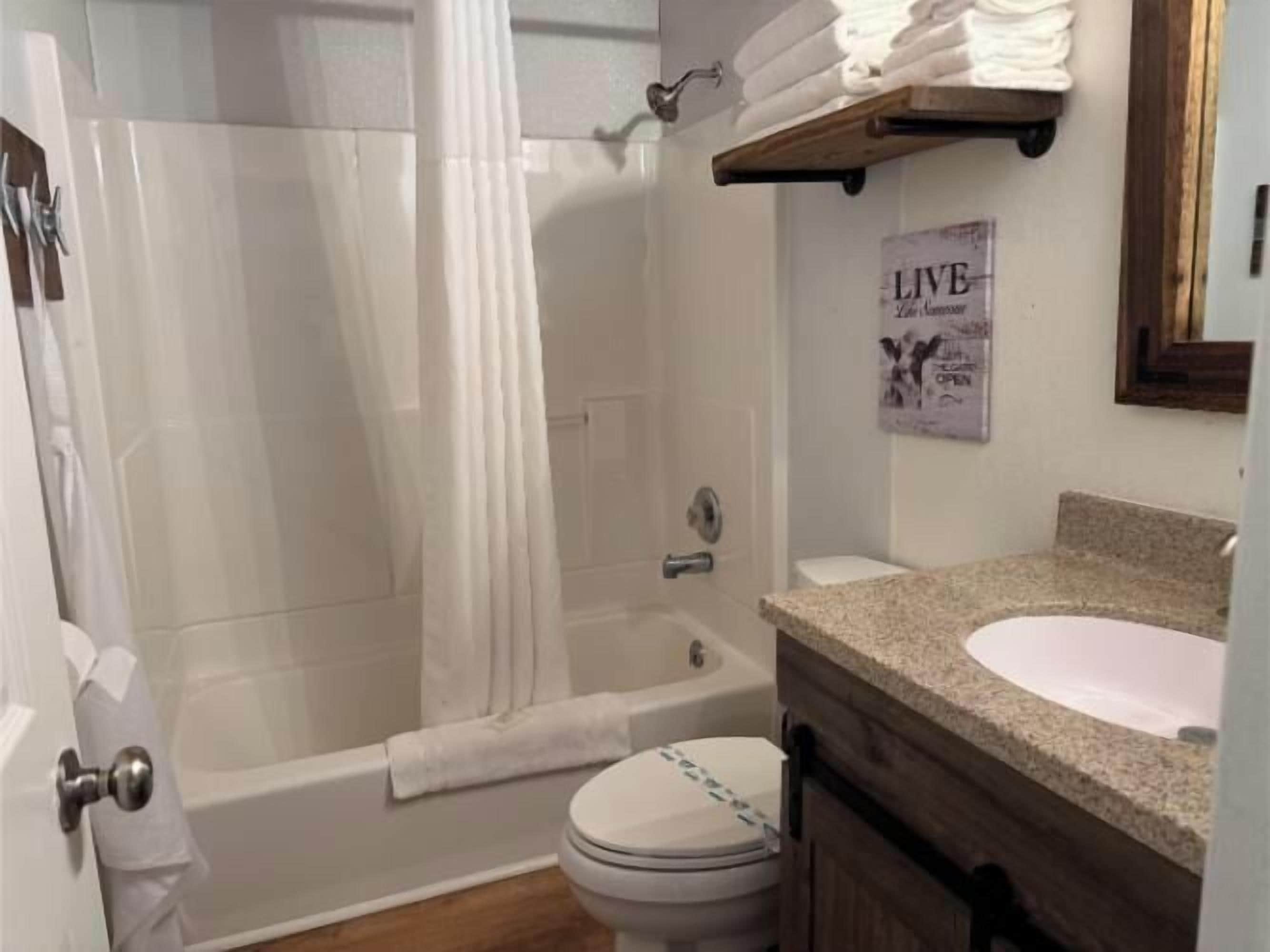 A bathroom with a bathtub, toilet, and sink.