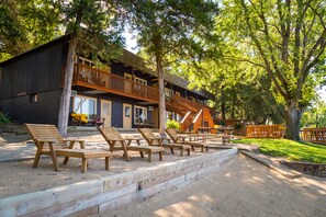 A wooden cabin with a deck and outdoor seating area.