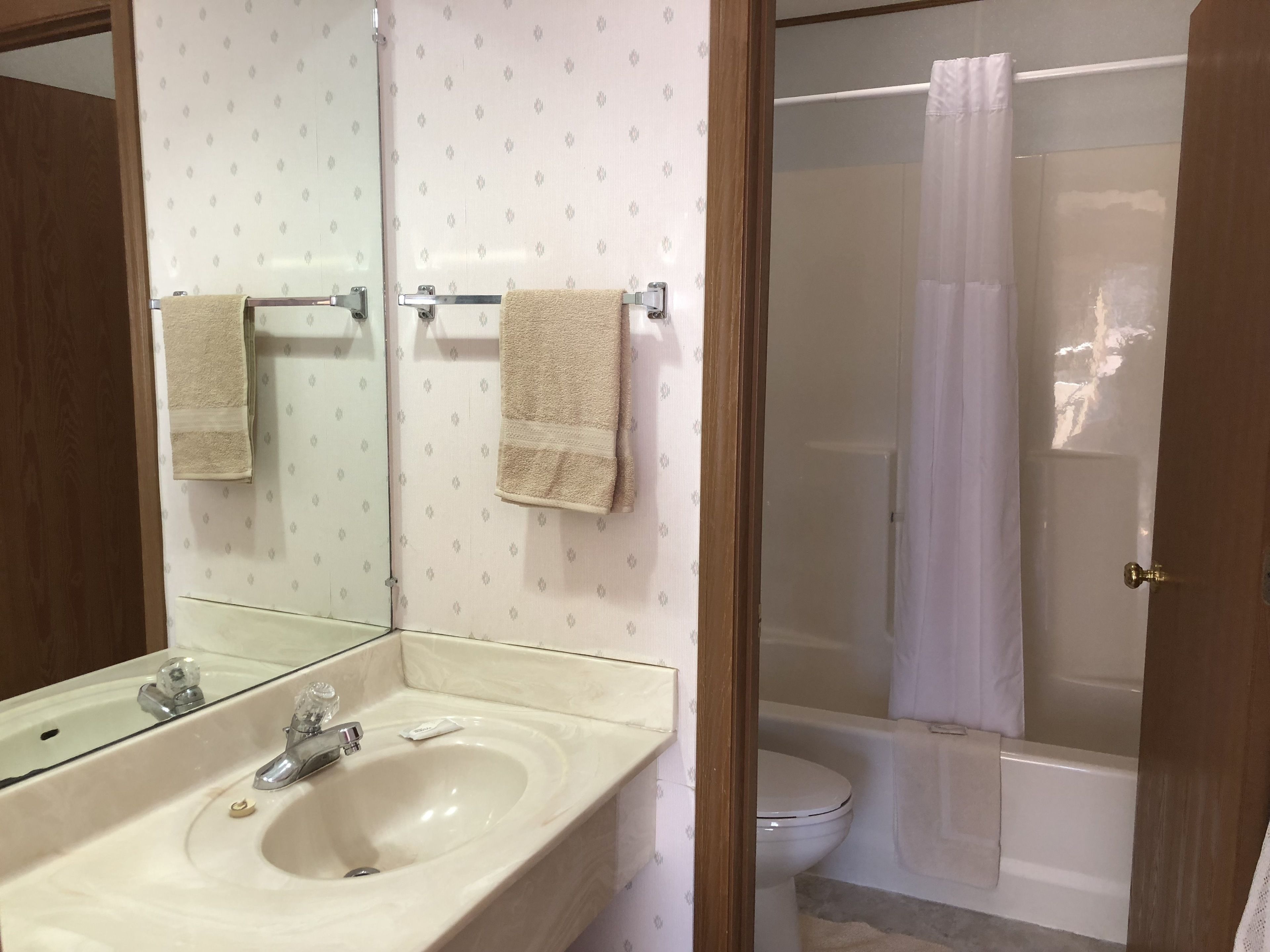 Ein Badezimmer mit Waschbecken, Spiegel und Duschbereich.