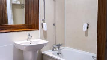 A bathroom with a sink, mirror, and bathtub.