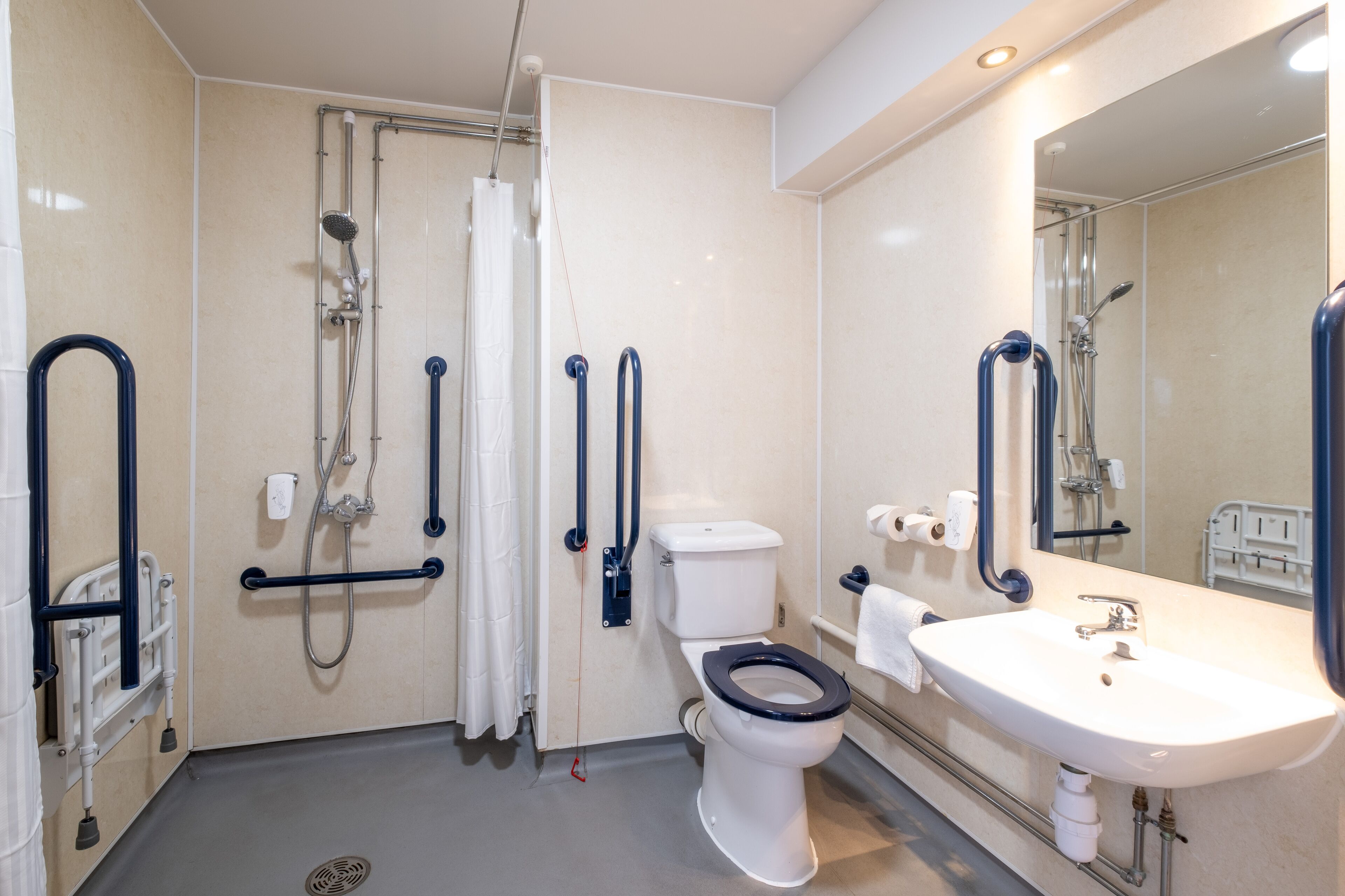 A bathroom with a white toilet, a sink, and a shower area.