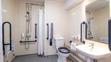 A bathroom with a white toilet, a sink, and a shower area.