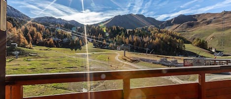 A mountain landscape with a clear sky and a bright sun.