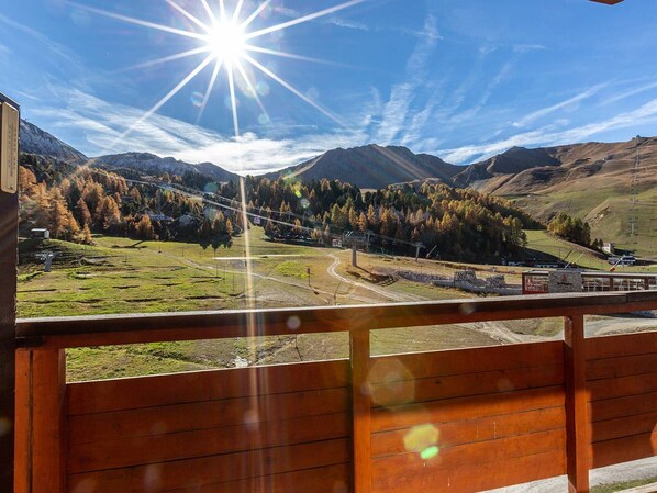 A mountain landscape with a clear sky and a bright sun.