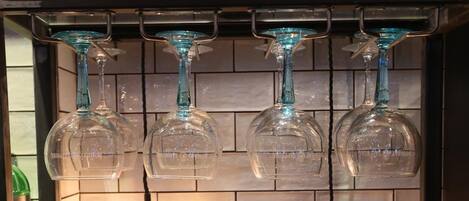 Zona de bar con varias botellas de licores y vasos.