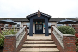 A two-story building with a dark blue facade, a black front door, and a small porch area with steps leading up to it. - Boundary, Alfreton by Marston's Inns (Alfreton)
