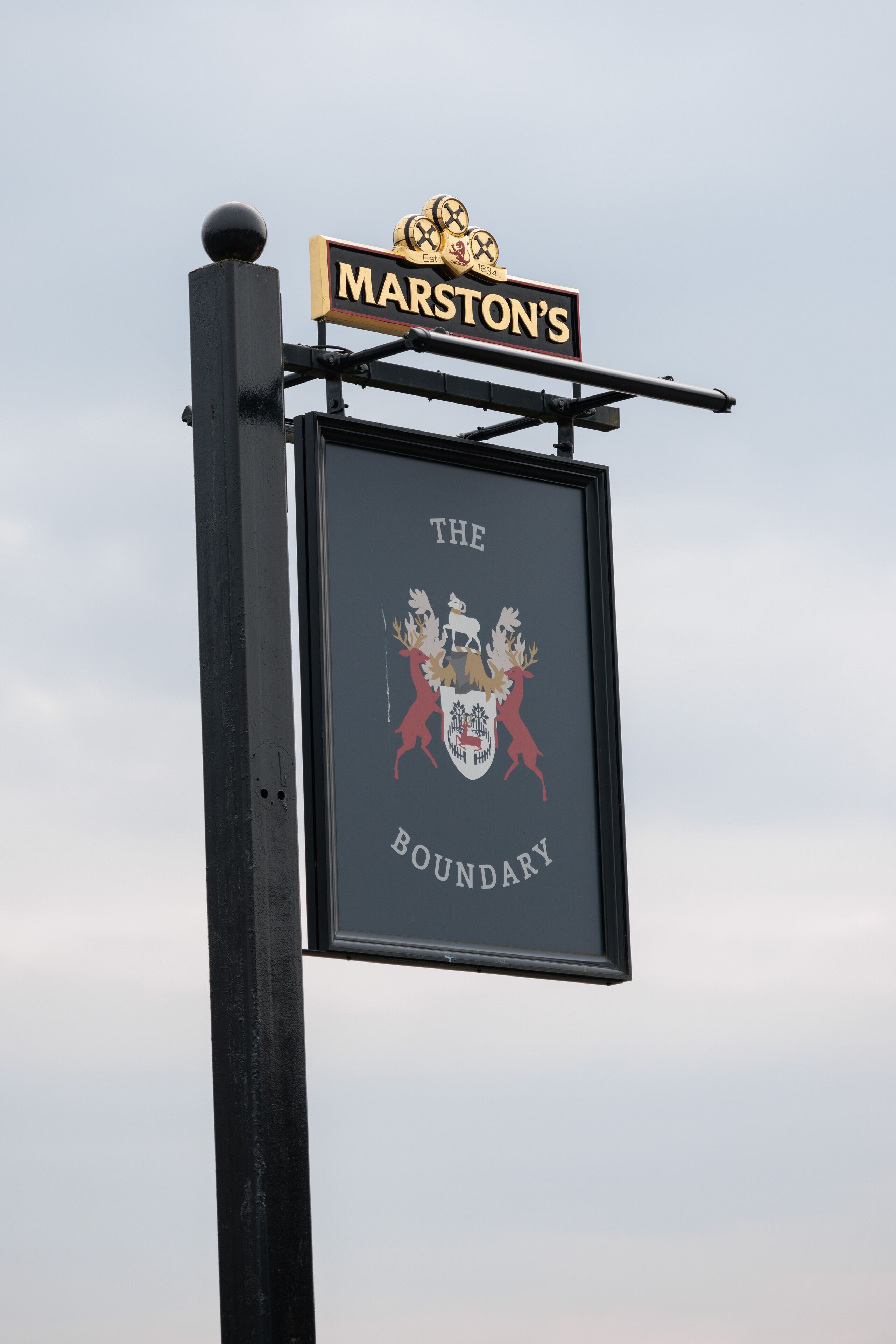 A sign with "MARS'TON'S" and a coat of arms.
