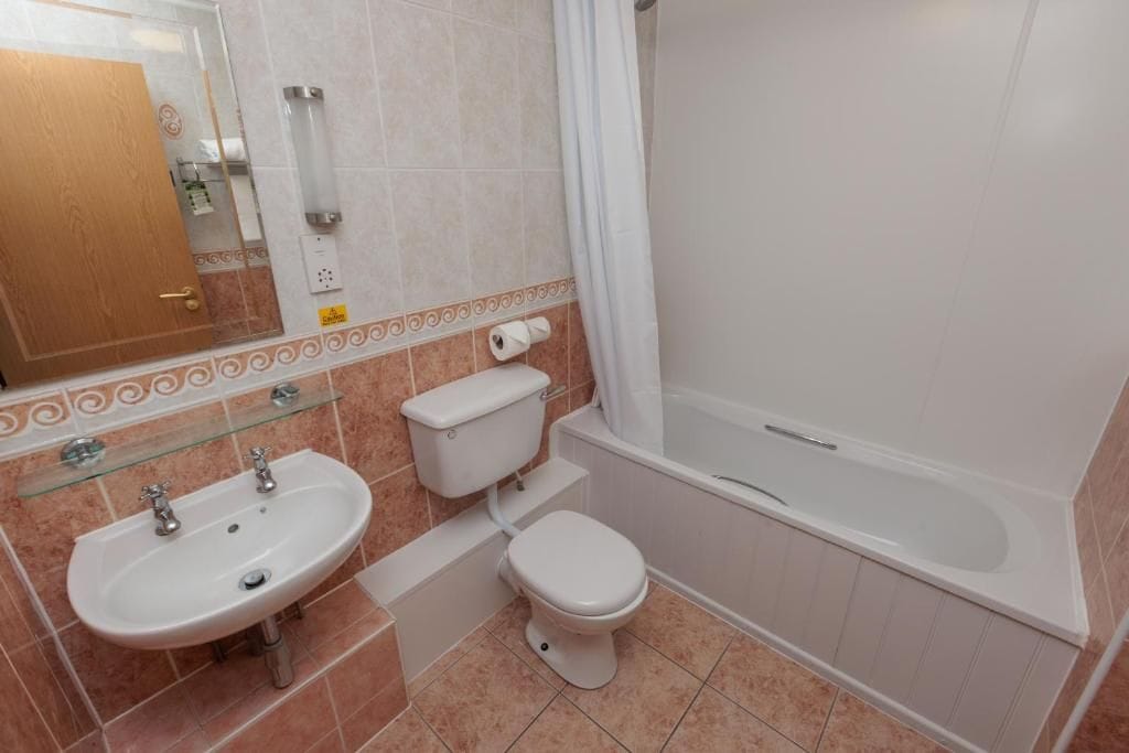 Une salle de bain avec un lavabo, des toilettes et une baignoire.