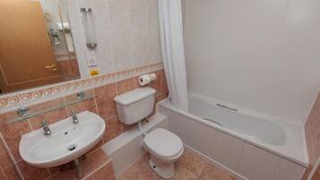 Une salle de bain avec un lavabo, des toilettes et une baignoire.