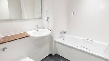 Un baño moderno con un lavamanos blanco, una bañera y un espejo.