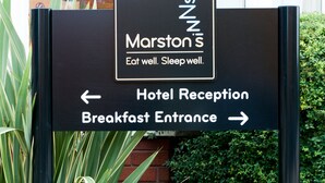 Schild für das Marston's Hotel mit Hinweisen zum Empfang und zum Frühstückseingang.
