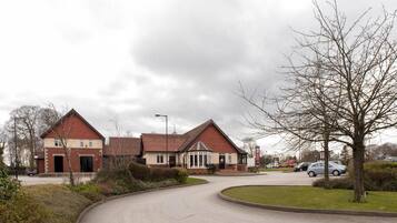 A residential area with a curved road leading to a row of houses with red roofs and white trim.