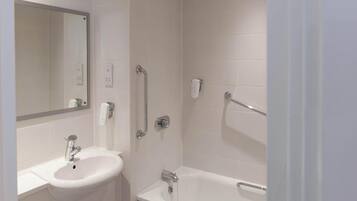Un baño con lavamanos, espejo y bañera.