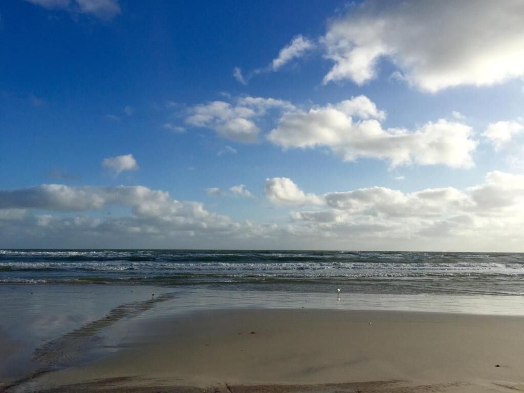 Una playa con cielo despejado y olas.