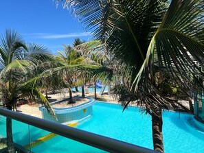 A pool area with palm trees and a clear blue sky.